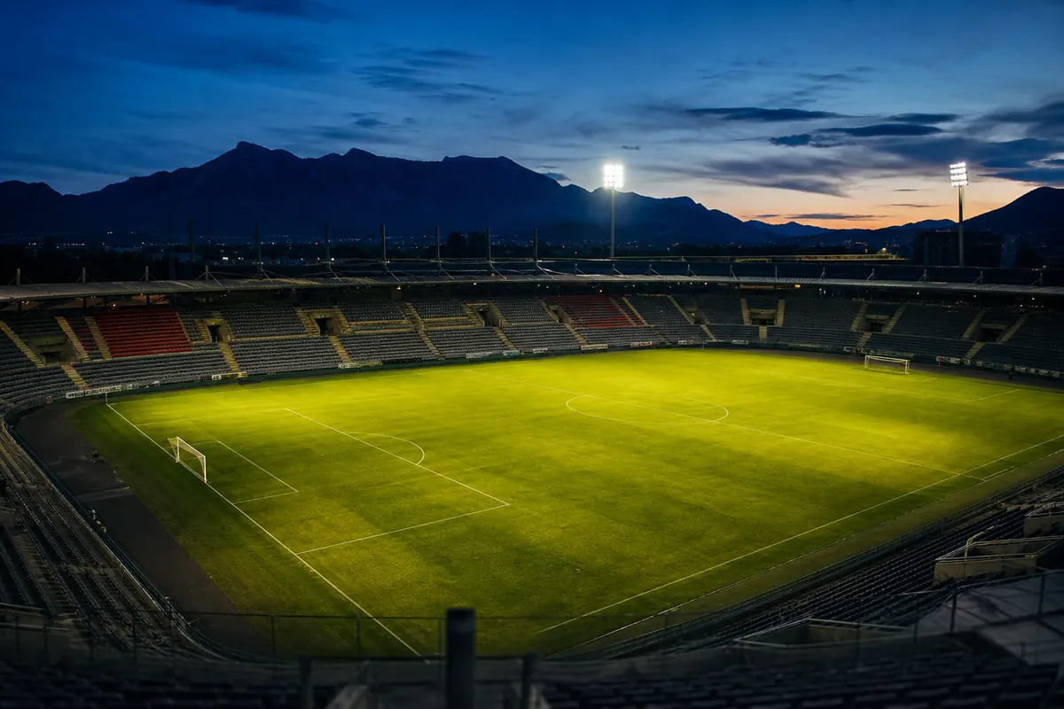 Flutlicht über einem Fußballstadion am Abend, Blick von der Pressetribüne